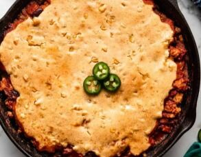 Chili prepared in a cast-iron with a corn bread topping!